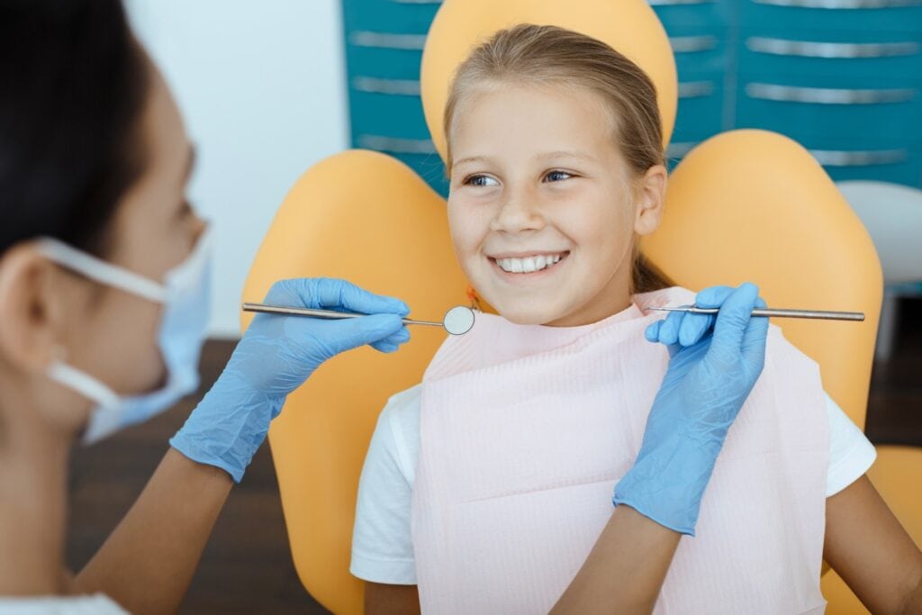 Jeune patiente souriante lors d’un examen dentaire - Soins de dentisterie esthétique Odontys